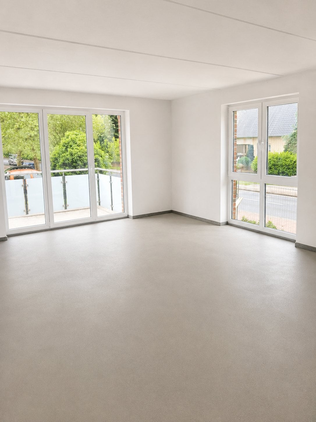 Heller Wohnraum mit bodentiefen Fenstern und Balkon in einem DOHOme-Wohnprojekt